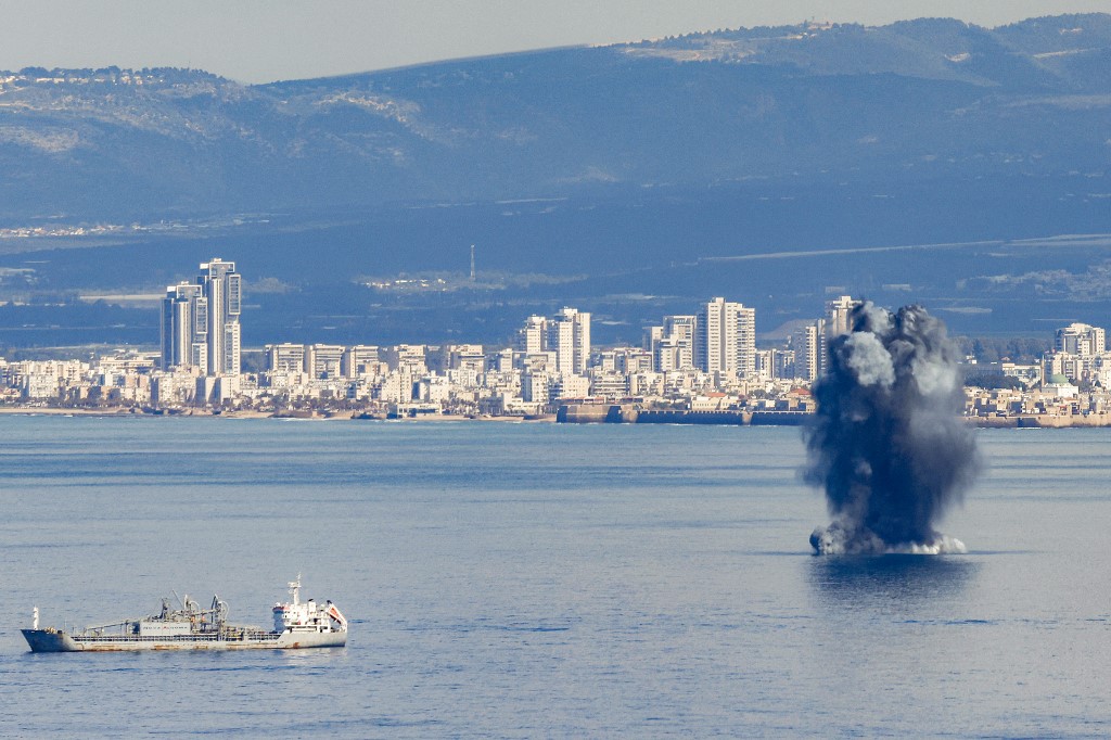 An incoming projectile explodes over the water in the bay of Haifa