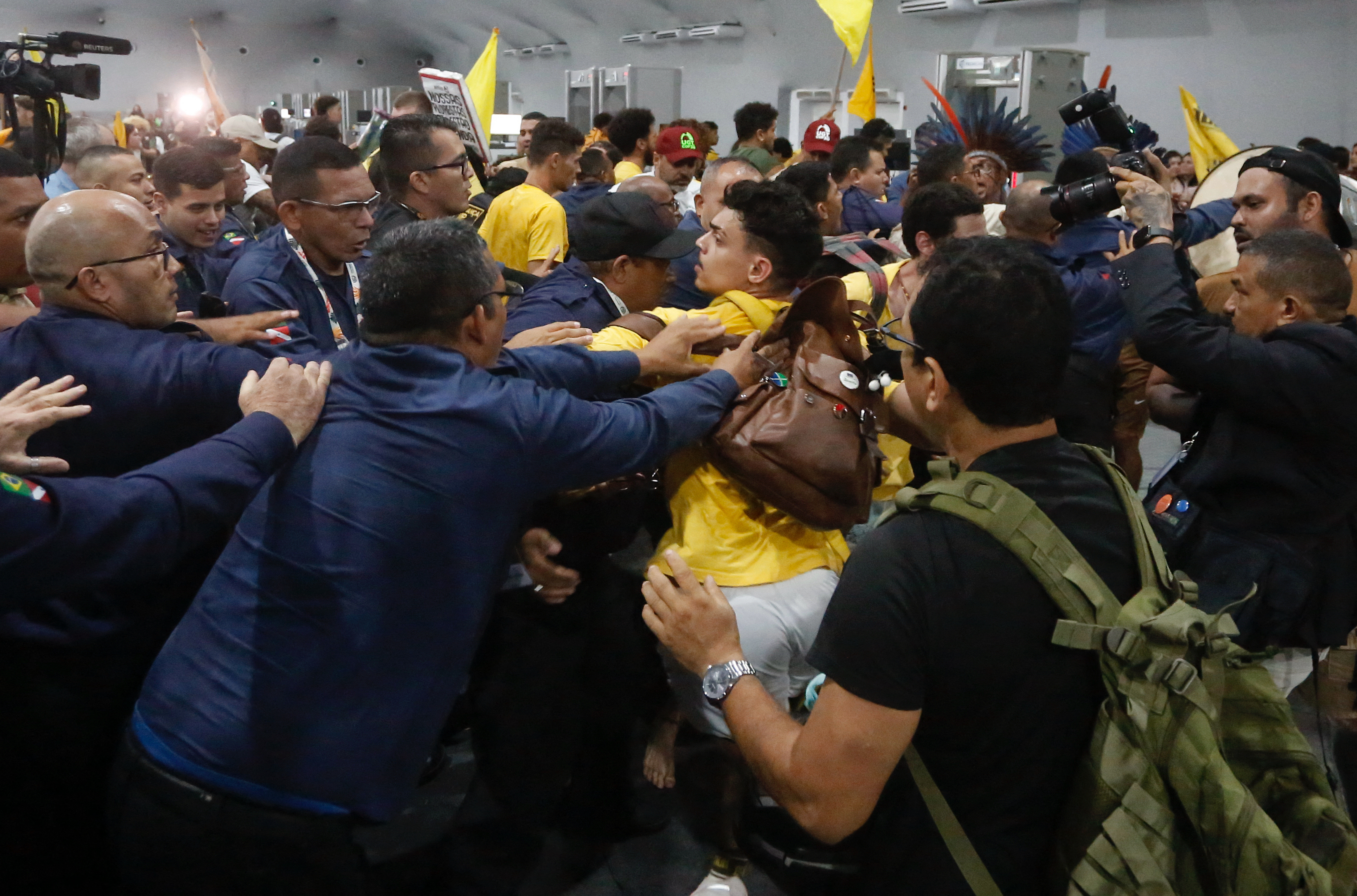 Security personnel clash with indigenous people and students as they storm the venue during the COP30