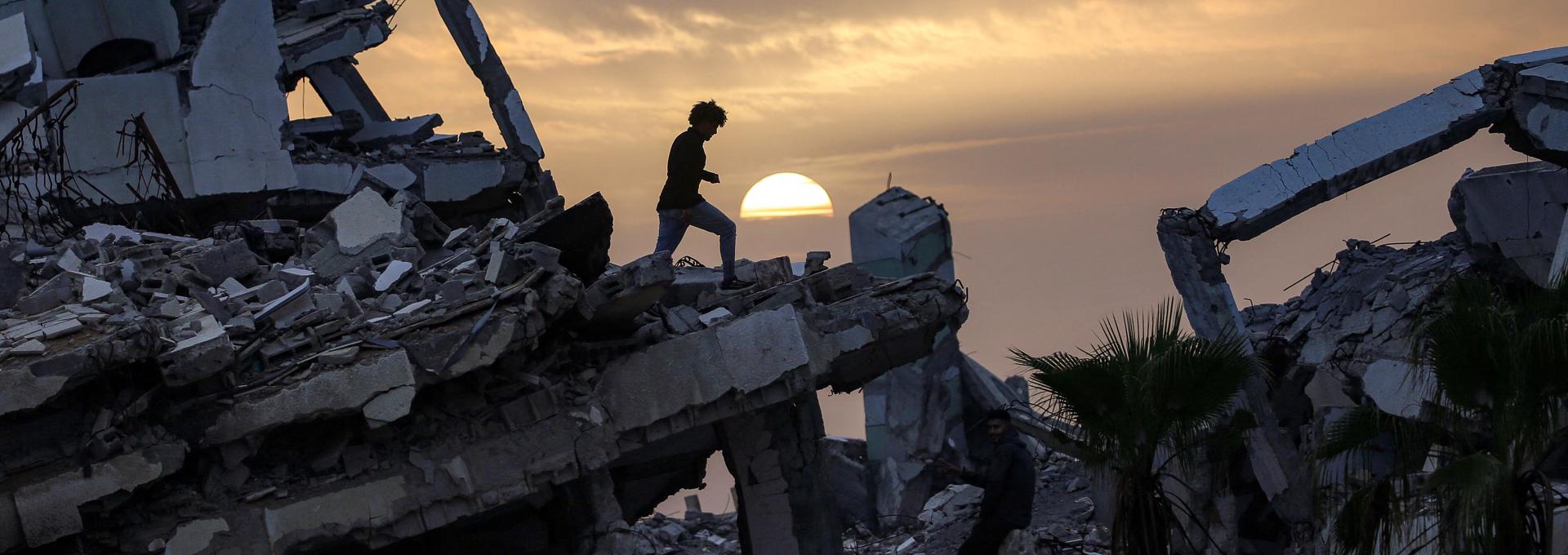 Un jeune marche le long des ruines d’un bâtiment détruit dans le quartier de Zahra, au sud-ouest de Nuseirat, dans le centre de la bande de Gaza.