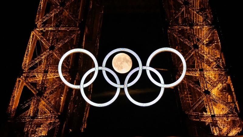 The moon rises behind the Olympic rings displayed on the Eiffel Tower in Paris on July 22, 2024, ahead of the Paris 2024 Olympic Games.. © Loic Venance / AFP 