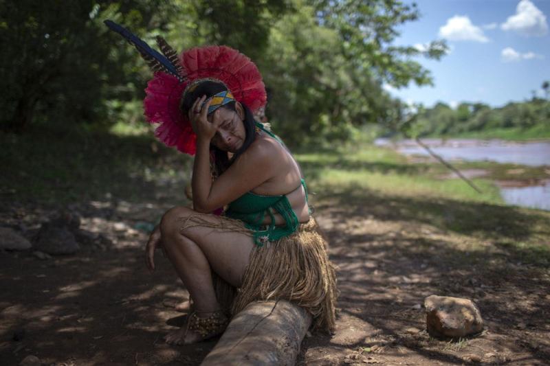 Una mujer indígena de la comunidad Pataxo Ha-ha-hae llora al mirar el río Paraopeba cubierto de barro, el sexto día después del colapso de una presa en una mina de hierro cerca de la ciudad de Brumadinho. Mauro Pimentel / AFP